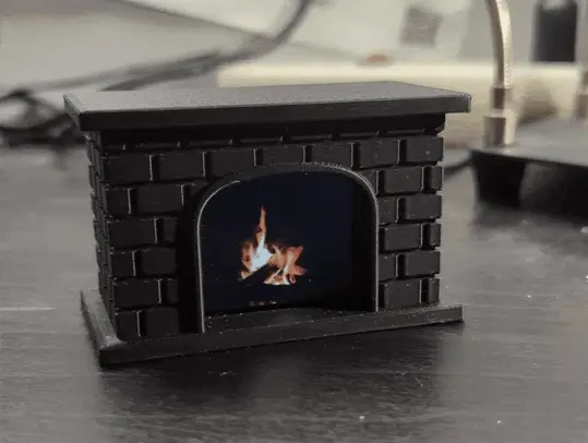 An animated picture of an all-black plastic fireplace with a little screen inside playing a fireplace animation.